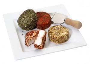 A platter with soft goat cheese covered with spices in different colors,isolated on white with clipping path.